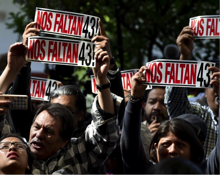 Family members of the 43 students display signs during the GIEI’s presentation of their findings on Sunday. Source: The New York Times.